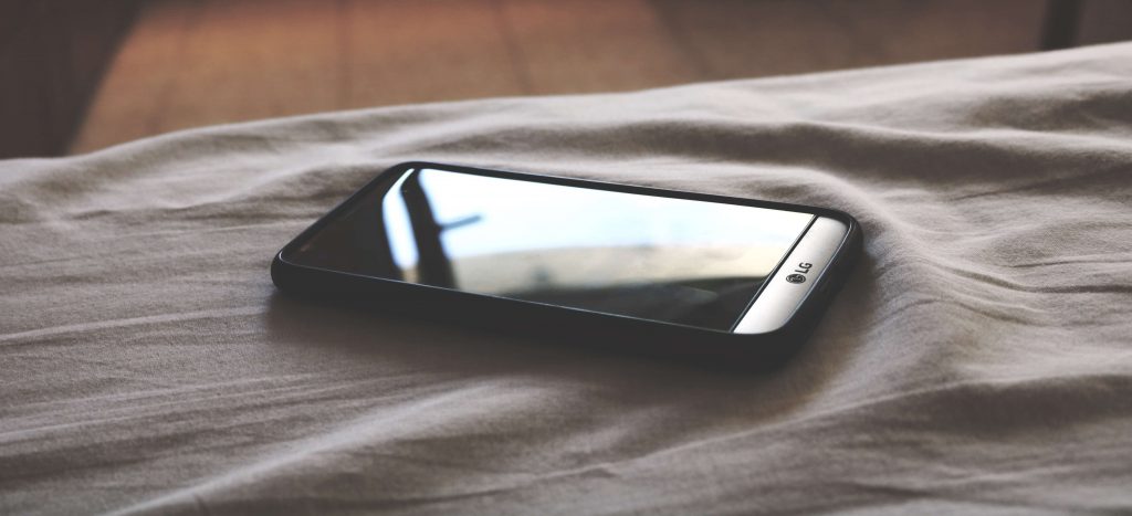 Shot of a mobile phone on a bed